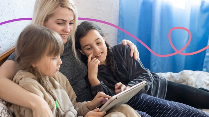 Mother sitting with her two daughters using a tablet device
