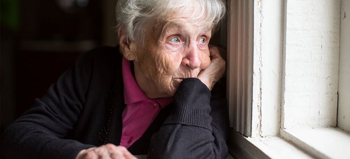 Dorothy, age 73, rests her head on her hand as she stares out a window. 