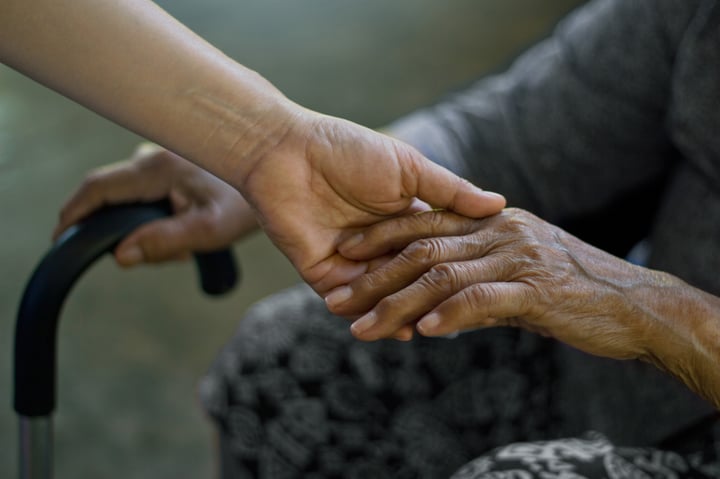 Elderly hand being held