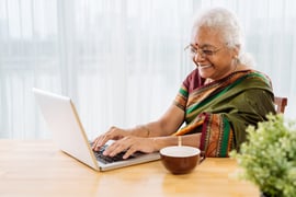 Smiling older woman sat at a laptop