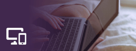 A laptop computer being held while sitting in bed