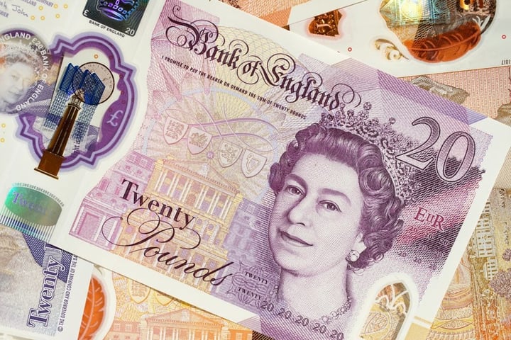 A-British-twenty-pound-note-placed-on-top-of-other-pound-notes.