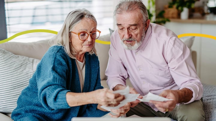 Elderly Caucasian husband and wife looking at their bills