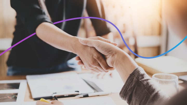Two people shaking hands, only their hands and arms are visible.
