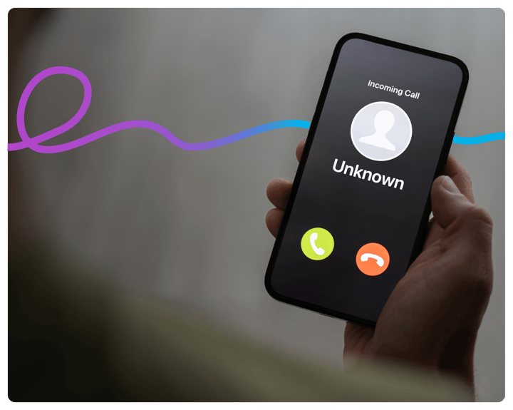 a hand holding a smart phone. The phone screen shows an unknown caller. 