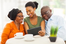 cheerful african family at home using tablet pc