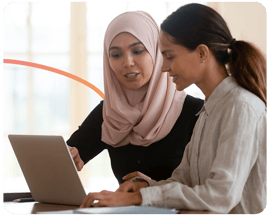 two women behind a laptop