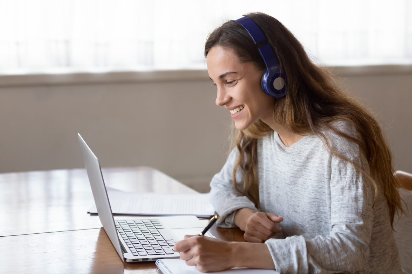 Woman looking at laptop screen with headphones on
