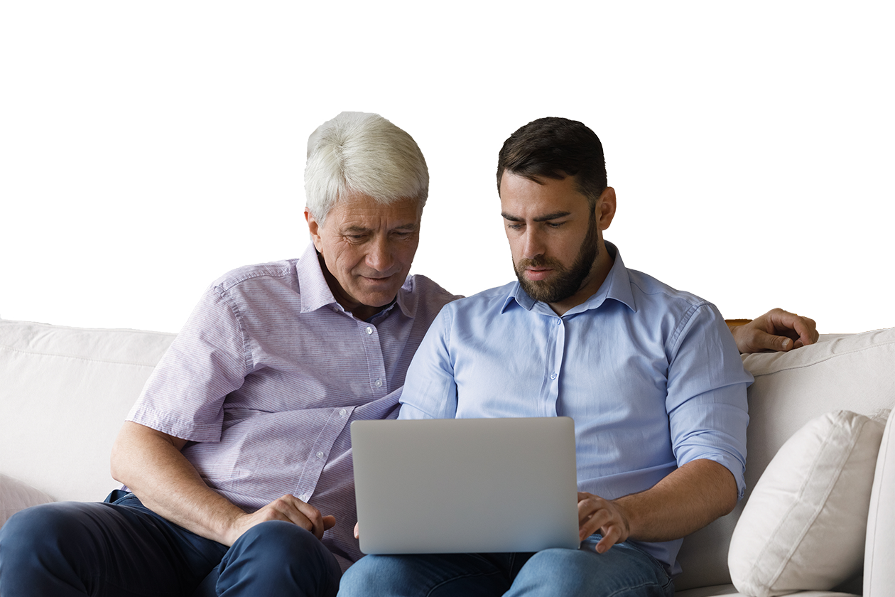 dad and son sat on sofa on laptop