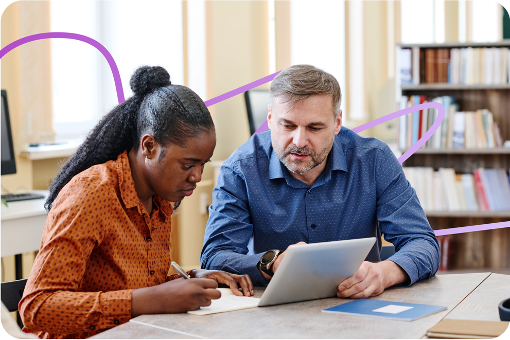 Two people looking at an iPad and making notes