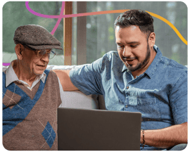Young man showing older man how to use computer