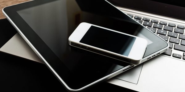 A laptop stacked with phone and tablet computer