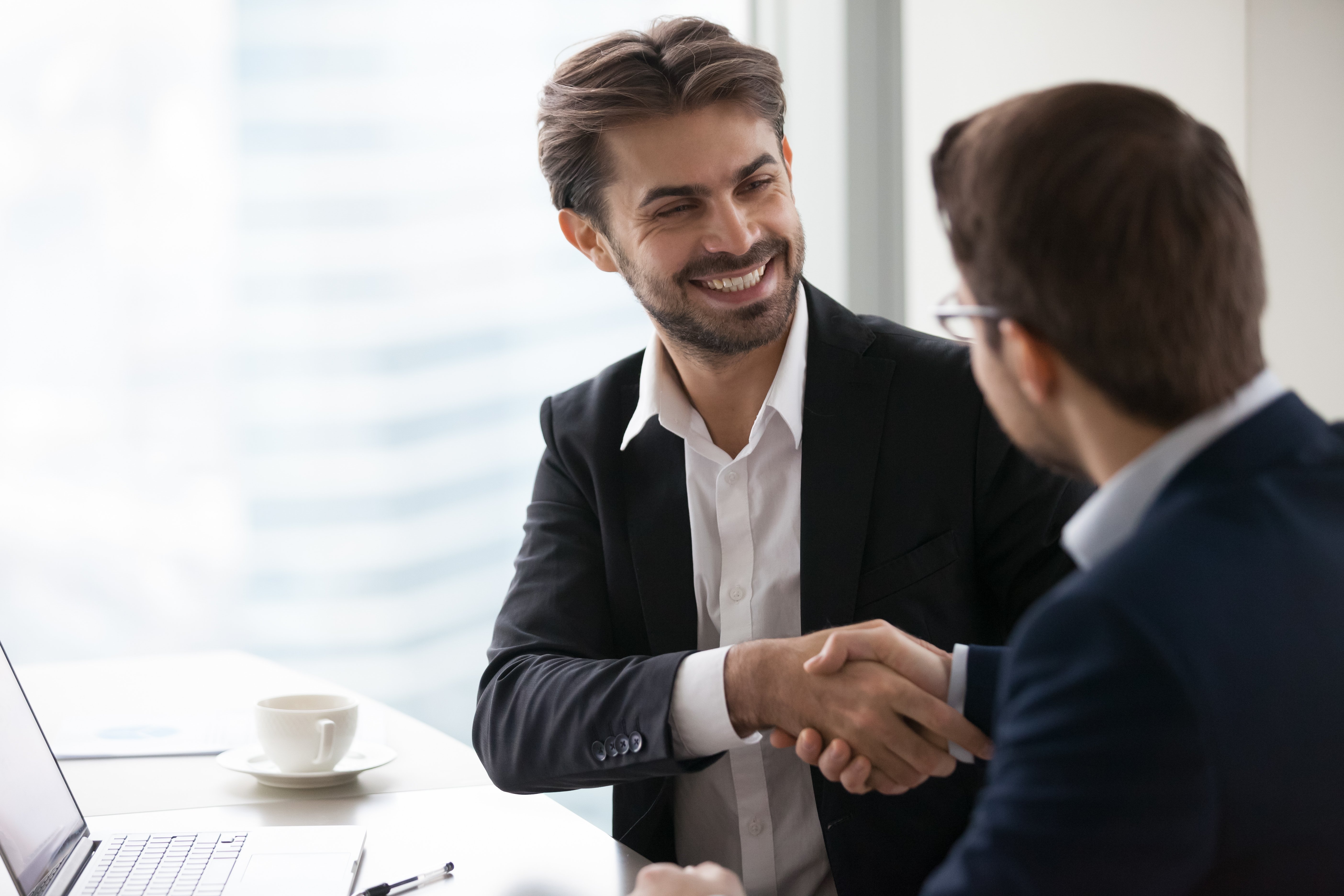 two men shaking hands closing a deal