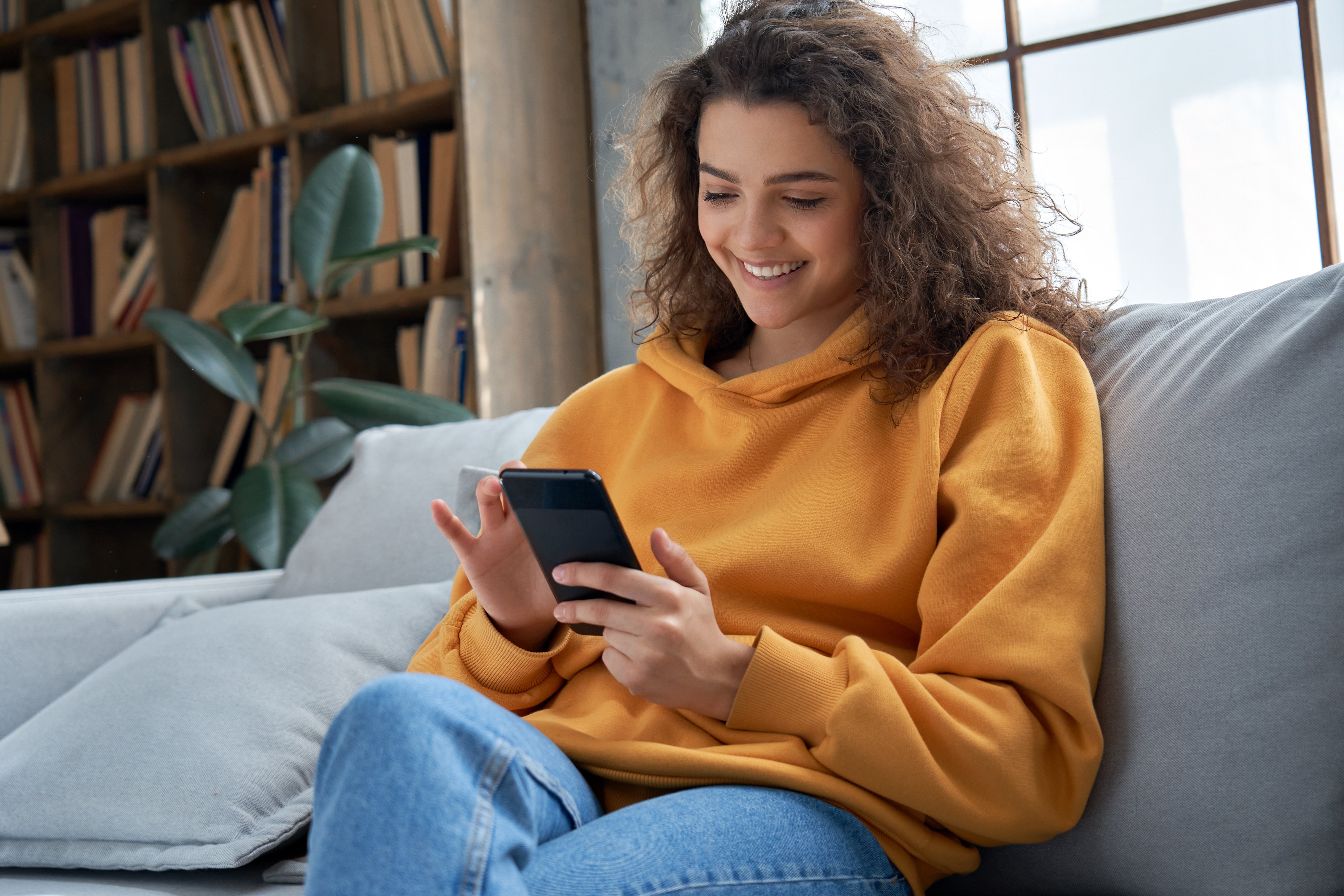 Woman on a sofa looking at her phone
