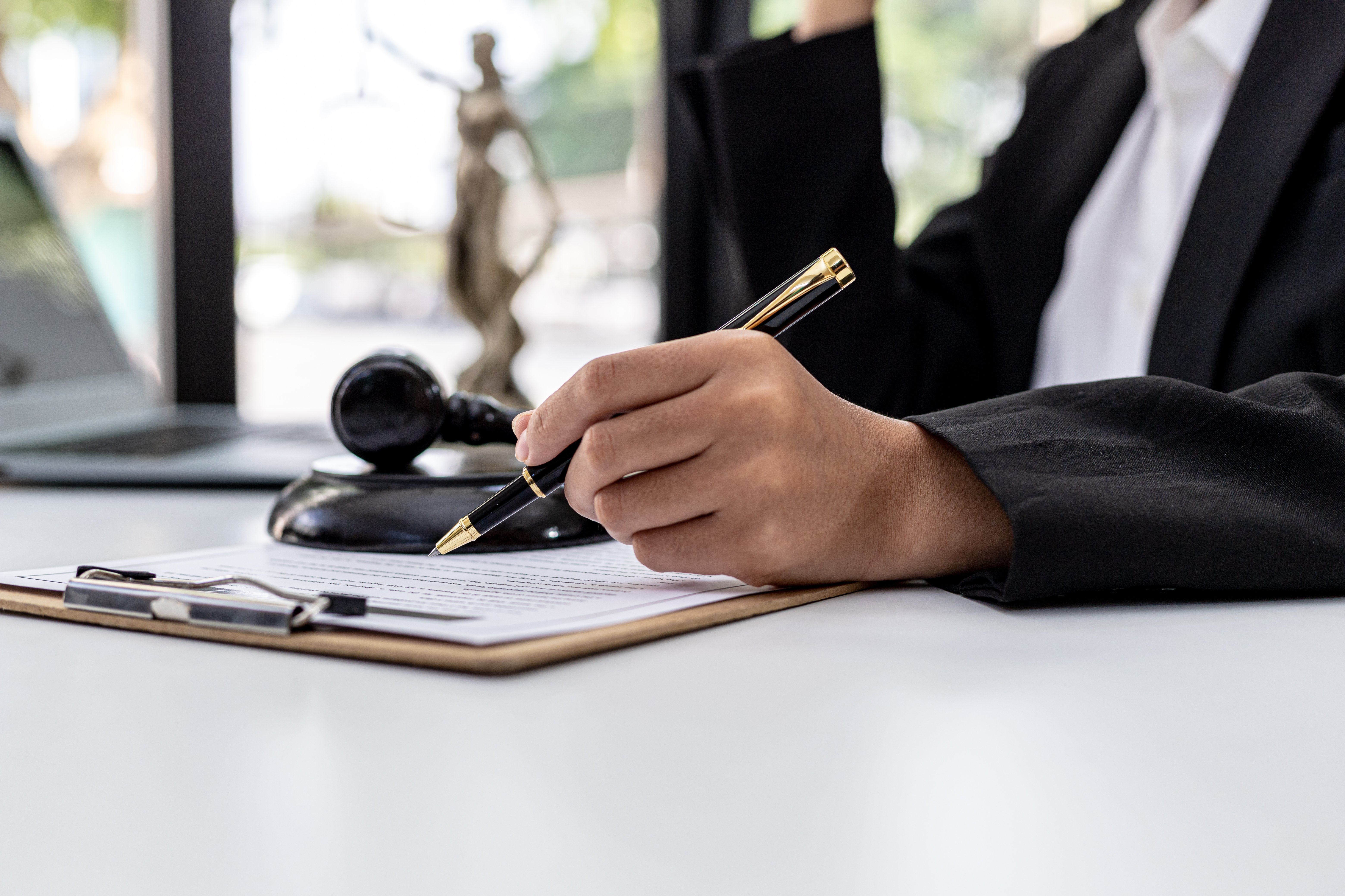 image of a hand holding a pen and paper writing a plea