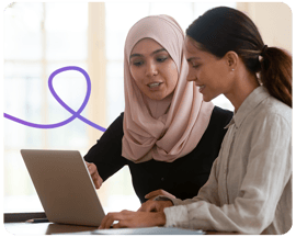 Woman training person on how to use a laptop