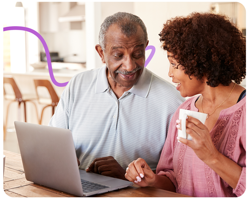 trainer showing older man how to use his laptop